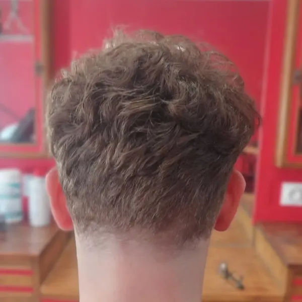 Coupe homme sur cheveux bouclés, nuque dégradée vue de dos