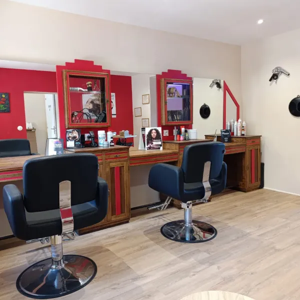 Les postes de coiffage aux miroirs rouges du salon La Boucle Rouge à Œting