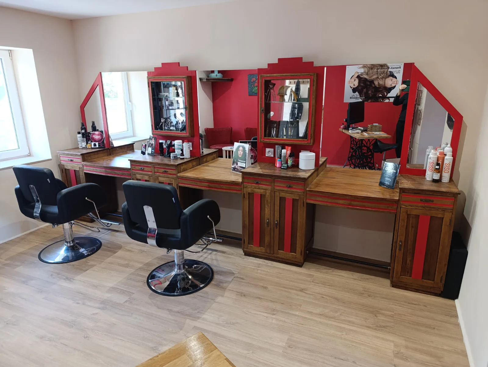 Intérieur du salon de coiffure La Boucle Rouge à Œting : postes de coiffage aux miroirs rouges